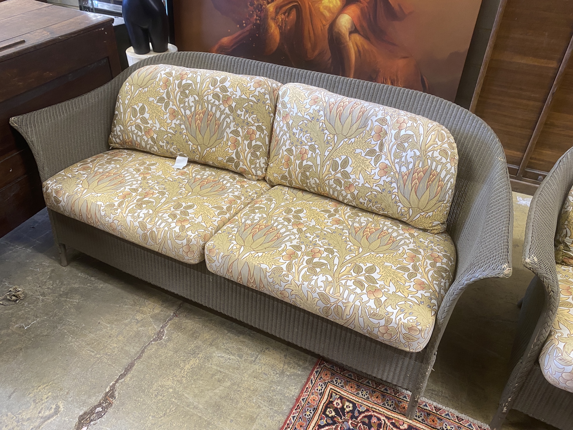 A pair of Lloyd Loom garden settees with William Morris fabric cushions, width 187cm, depth 74cm, height 81cm